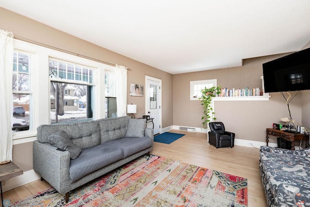 living area featuring baseboards, visible vents, and wood finished floors
