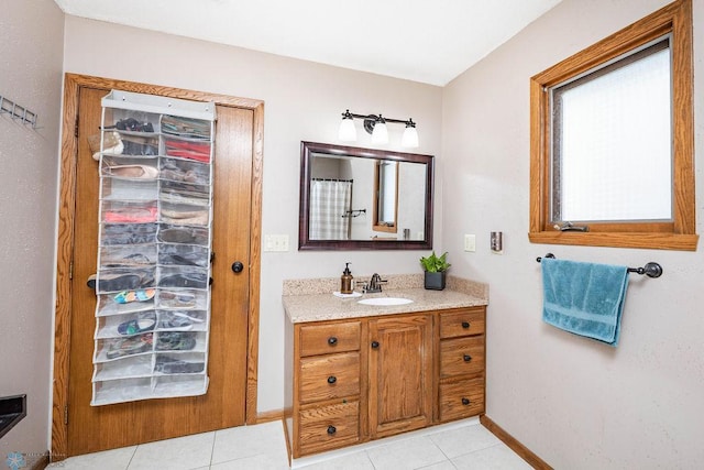 full bath with tile patterned floors, baseboards, and vanity