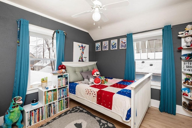 bedroom with a ceiling fan, vaulted ceiling, and wood finished floors