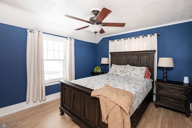 bedroom featuring light wood-type flooring, baseboards, a ceiling fan, and lofted ceiling