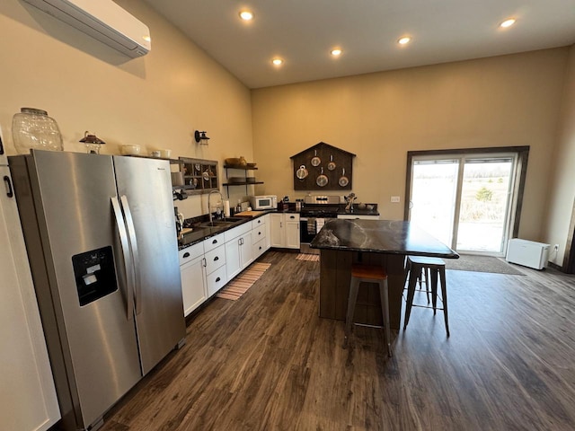 504 Lakin Ave NW, Kelliher, MN 56650 - kitchen with dark wood finished floors, a sink, an AC wall unit, stainless steel appliances, and white cabinetry
