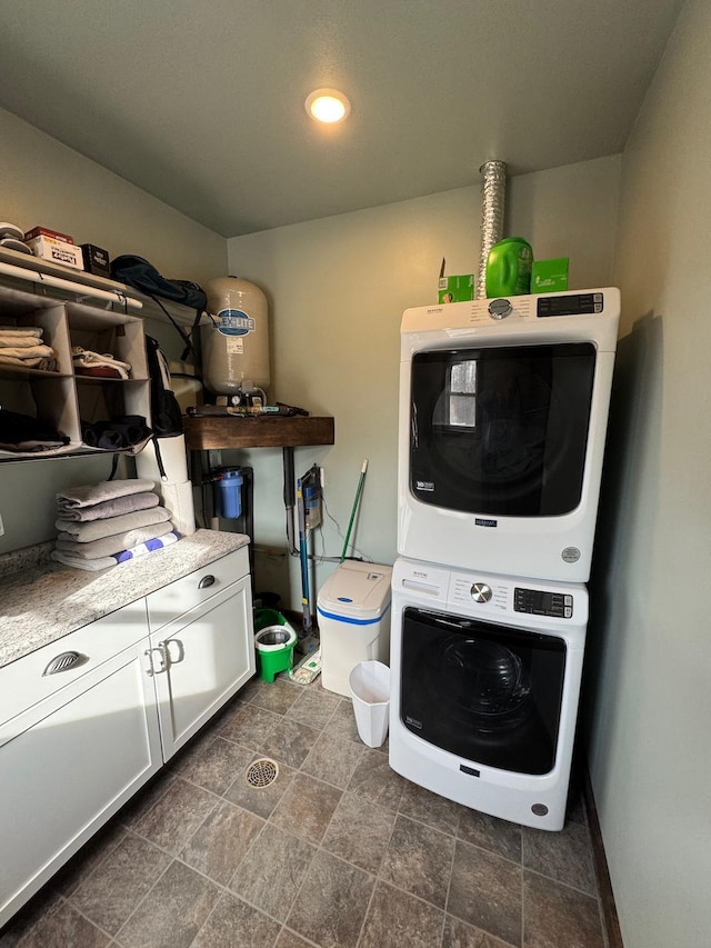 504 Lakin Ave NW, Kelliher, MN 56650 - washroom with recessed lighting, stone finish flooring, cabinet space, and stacked washing maching and dryer