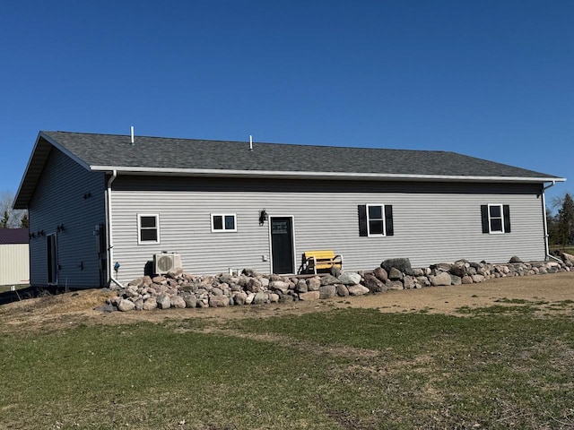 504 Lakin Ave NW, Kelliher, MN 56650 - rear view of property with a lawn, ac unit, and roof with shingles