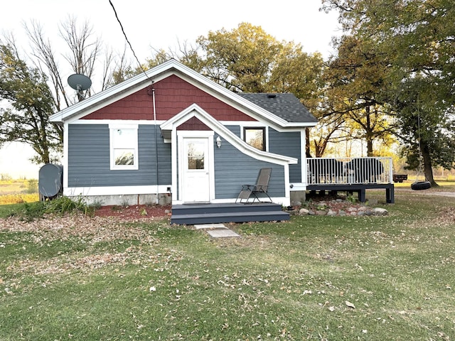 rear view of house featuring a yard and a wooden deck