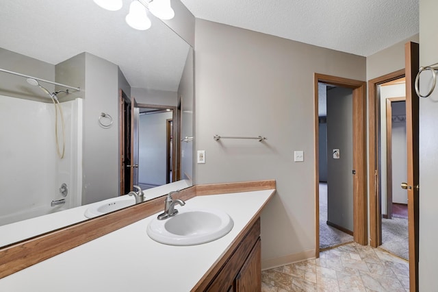 bathroom featuring baseboards, vanity, a textured ceiling, and bathing tub / shower combination