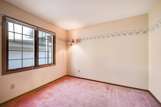 empty room featuring baseboards, visible vents, and carpet flooring