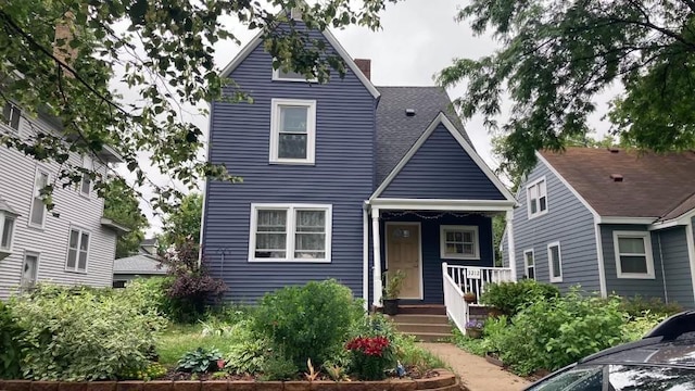 view of front of property featuring a chimney and covered porch