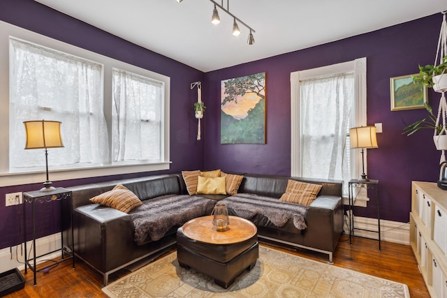 living room with track lighting and wood finished floors