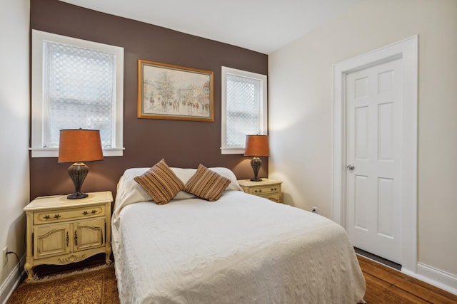 bedroom featuring baseboards and dark wood finished floors