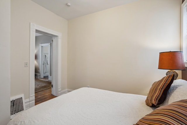 bedroom featuring visible vents, baseboards, and wood finished floors