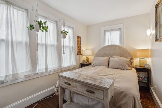 bedroom with dark wood-style flooring and baseboards