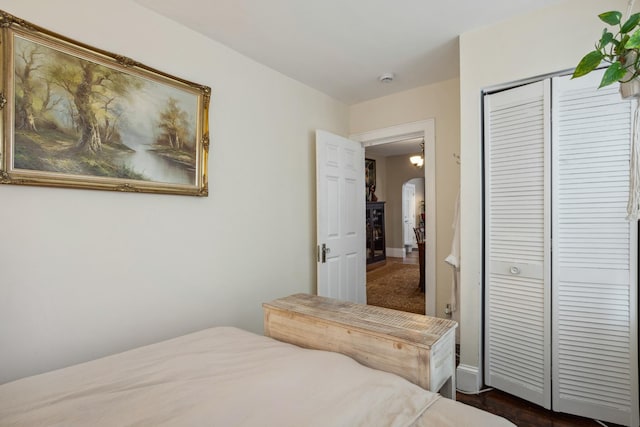 bedroom with a closet and arched walkways