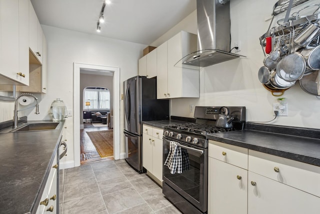 kitchen with exhaust hood, white cabinetry, dark countertops, a sink, and stainless steel appliances