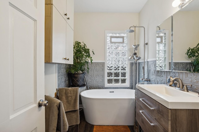 bathroom featuring a freestanding tub, vanity, a wainscoted wall, a shower, and tile walls