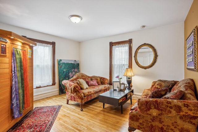 living area featuring light wood-style flooring, a wealth of natural light, and baseboards