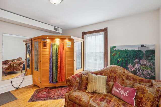 living room featuring visible vents, baseboards, and wood finished floors