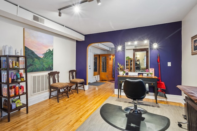 office area featuring visible vents, arched walkways, and wood finished floors