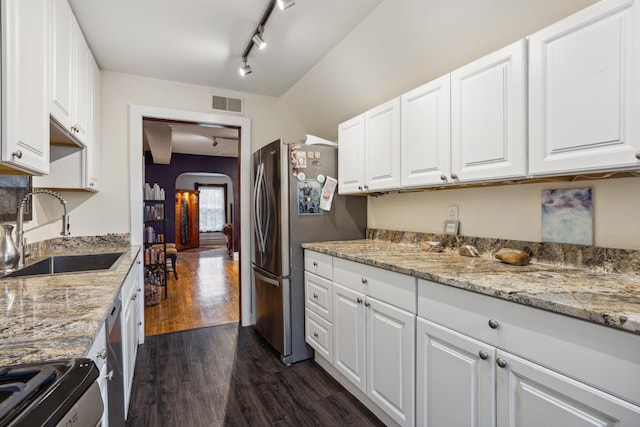 kitchen with rail lighting, visible vents, appliances with stainless steel finishes, arched walkways, and a sink