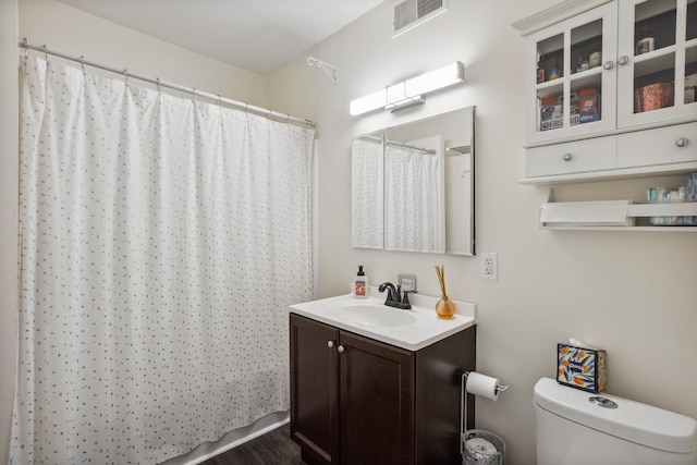full bath with toilet, vanity, visible vents, and a shower with curtain