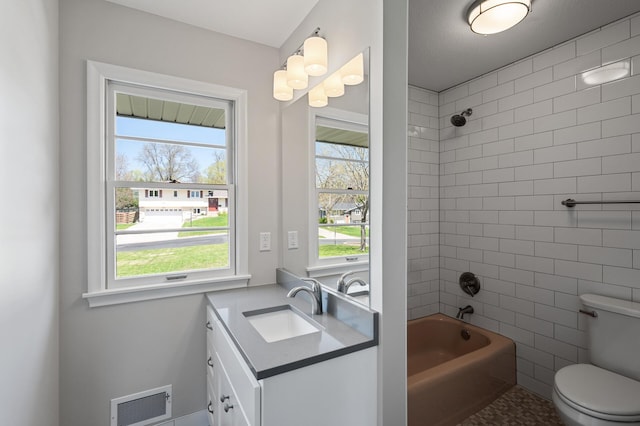 bathroom with vanity, bathtub / shower combination, toilet, and plenty of natural light