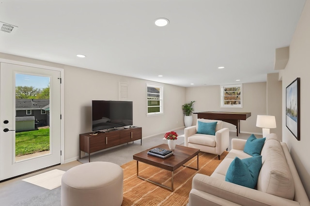 living room with plenty of natural light, recessed lighting, baseboards, and light colored carpet