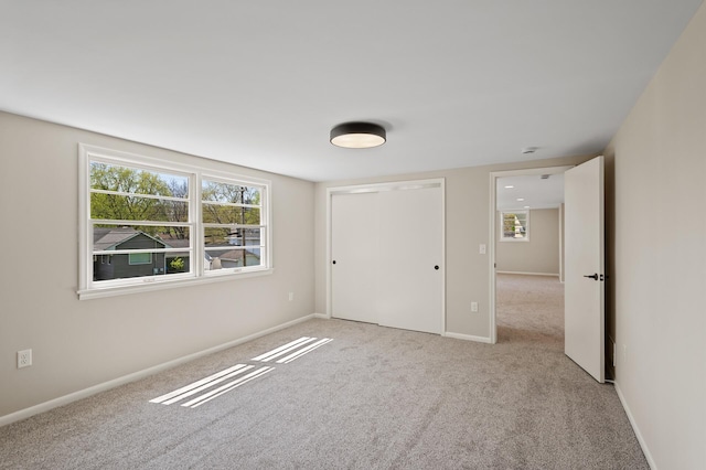 unfurnished bedroom featuring carpet, a closet, and baseboards