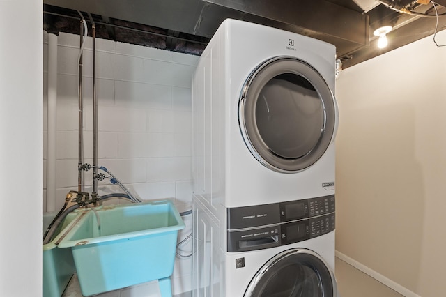 clothes washing area featuring estacked washer and dryer
