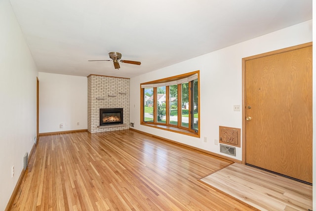 4926 Madison St NE, Columbia Heights, MN 55421 - unfurnished living room featuring ceiling fan, light wood finished floors, and a brick fireplace