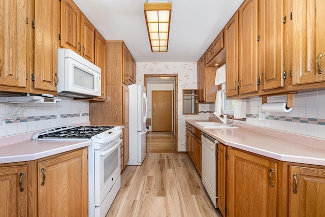 4926 Madison St NE, Columbia Heights, MN 55421 - kitchen with white appliances, light wood finished floors, decorative backsplash, brown cabinetry, and wallpapered walls
