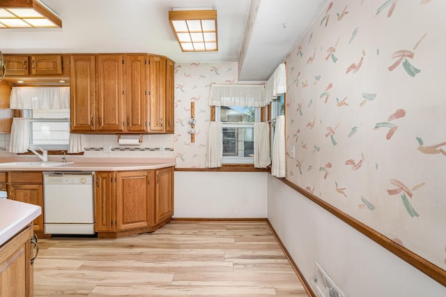 4926 Madison St NE, Columbia Heights, MN 55421 - kitchen featuring dishwasher, light wood-style flooring, light countertops, brown cabinets, and wallpapered walls