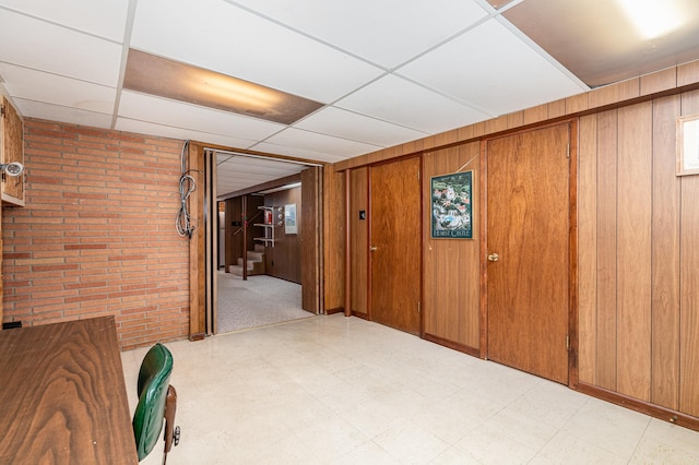 4926 Madison St NE, Columbia Heights, MN 55421 - hallway featuring light floors, brick wall, a paneled ceiling, and wood walls