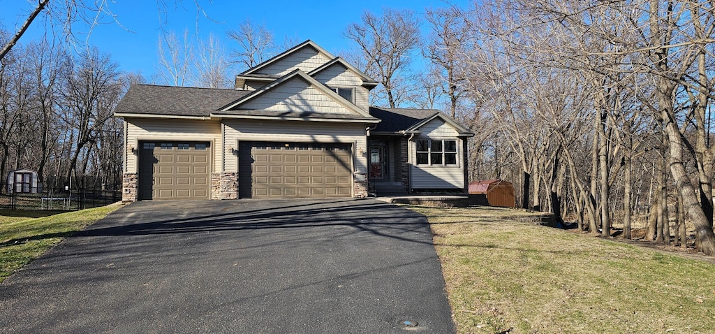 22922 Silverod St NW, Saint Francis, MN 55070 - view of front of house featuring an attached garage, stone siding, a front lawn, and driveway