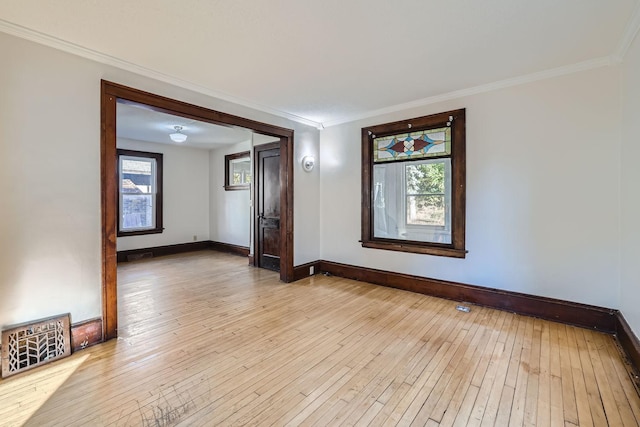 unfurnished room featuring light wood-style floors, visible vents, baseboards, and crown molding