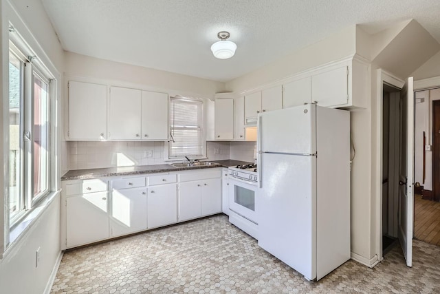 kitchen with a sink, tasteful backsplash, white cabinetry, and white appliances