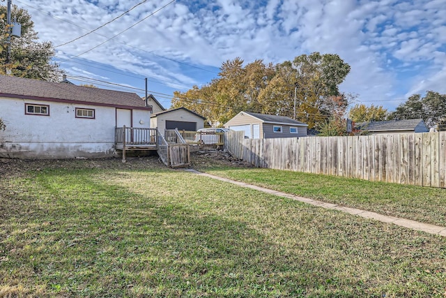 view of yard with a shed, fence, and an outbuilding