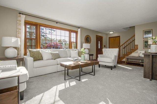 living area featuring stairway and carpet