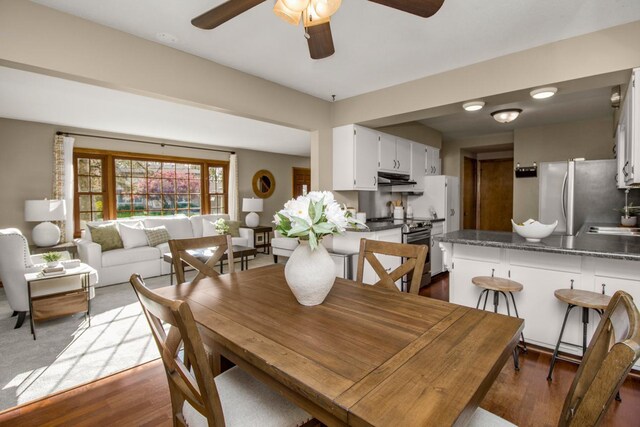 dining area featuring a ceiling fan and dark wood-style floors