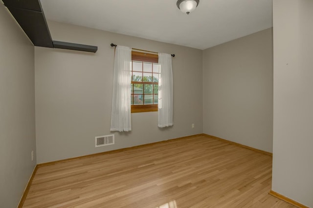 spare room with wood finished floors and baseboards