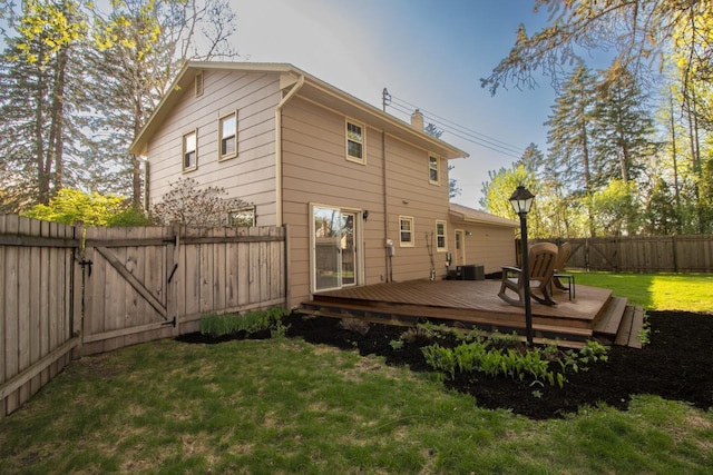 rear view of property with a deck, a chimney, a gate, and central AC unit
