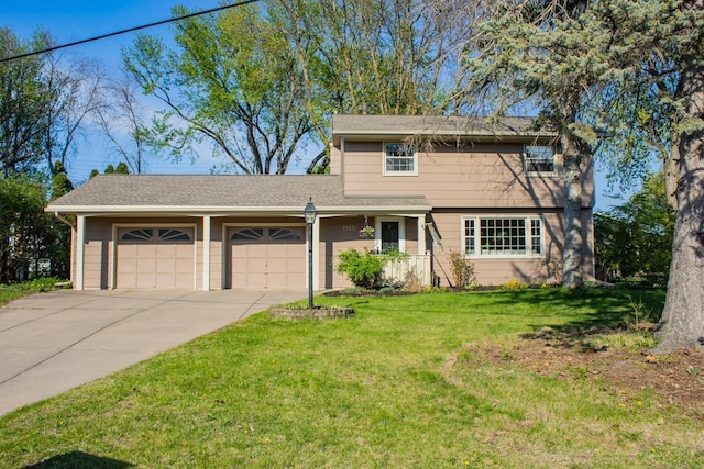 view of front of house with an attached garage, concrete driveway, and a front yard