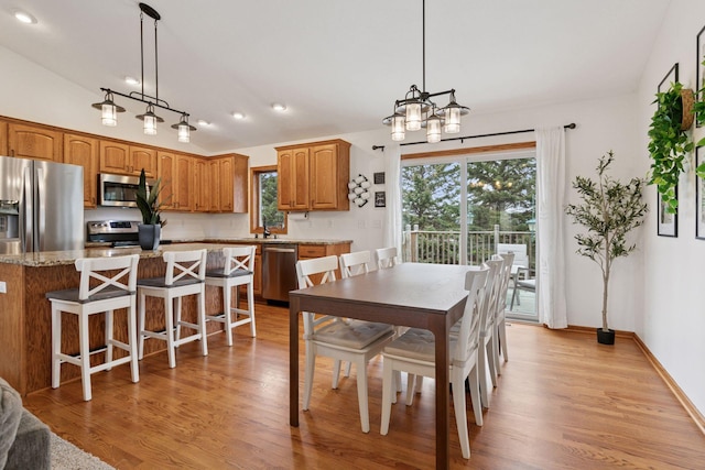 dining area with light wood-style floors, vaulted ceiling, recessed lighting, a chandelier, and baseboards