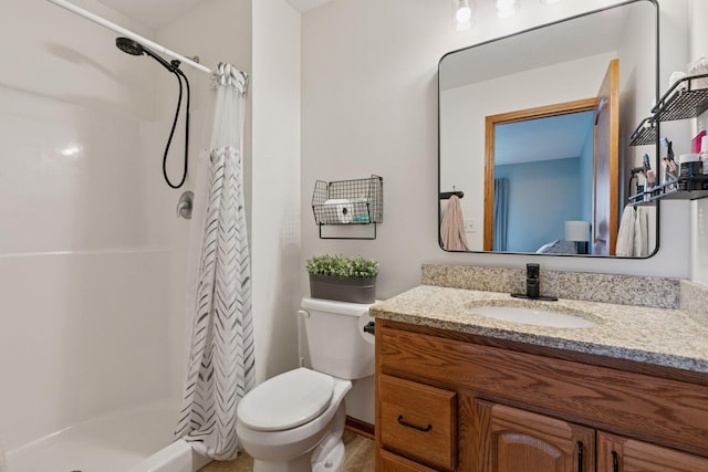 bathroom featuring a stall shower, vanity, and toilet