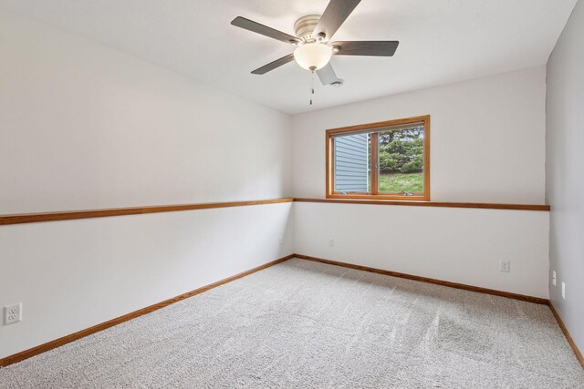 spare room with carpet floors, ceiling fan, and baseboards