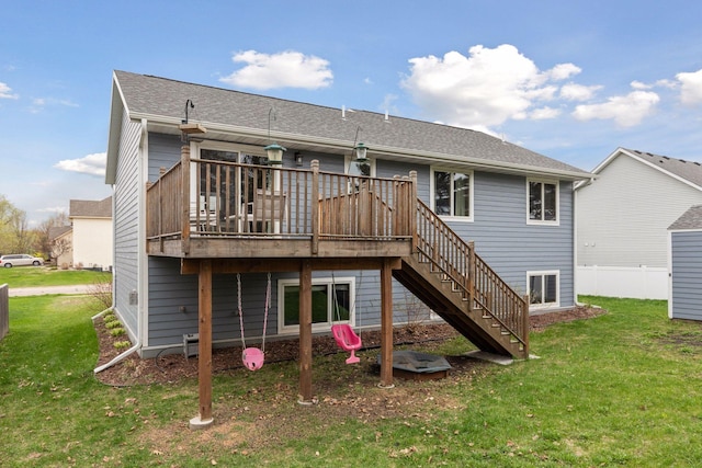 rear view of house with stairway, a deck, and a yard