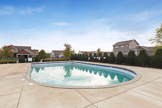 community pool with fence and a residential view
