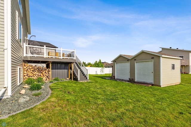 view of yard featuring stairs, a wooden deck, fence, and an outbuilding