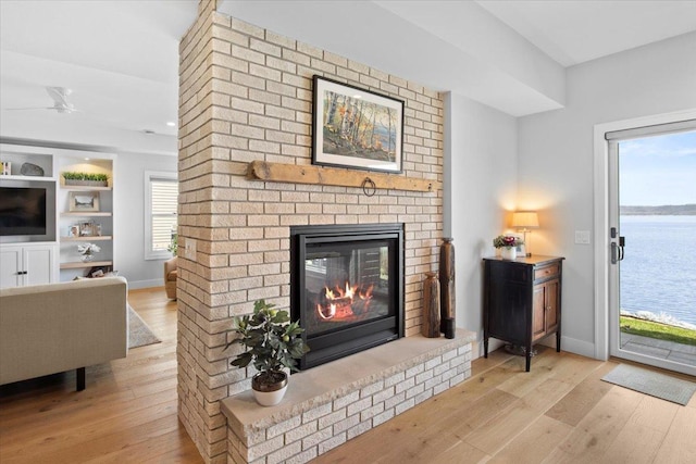 2041 Oak St, Lake City, MN 55041 - living room featuring wood-type flooring, a brick fireplace, and baseboards