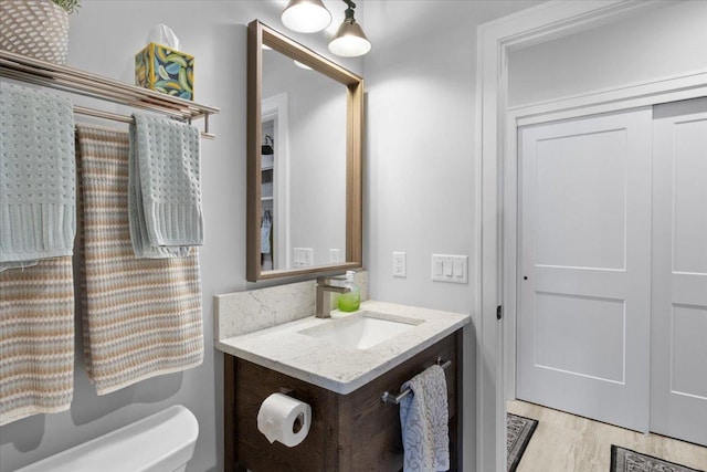 2041 Oak St, Lake City, MN 55041 - half bathroom with toilet, vanity, and wood finished floors