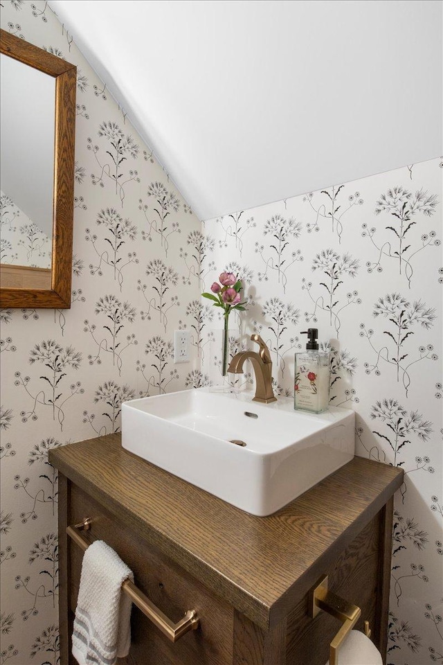 2041 Oak St, Lake City, MN 55041 - bathroom with vaulted ceiling, vanity, and wallpapered walls