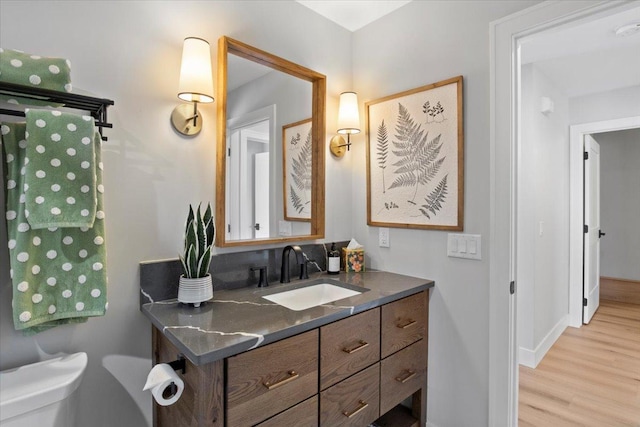 2041 Oak St, Lake City, MN 55041 - bathroom featuring baseboards, wood finished floors, vanity, and toilet